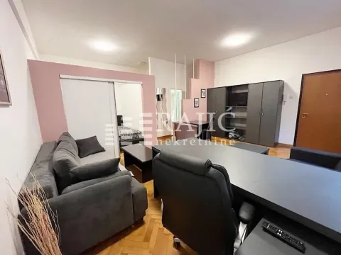 Living room with a sofa and an office desk. - image 2