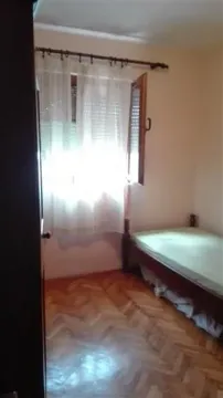 Mala spavaća soba sa jednim krevetom i parketom. - image 7