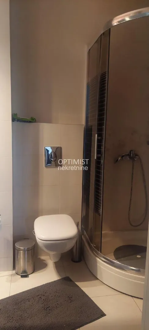 Kupatilo opremljeno WC šoljom i tuš kabinom.