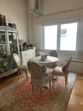 Trpezarija sa okruglim stolom, četiri stolice i vitrinom pored prozora. - image 8