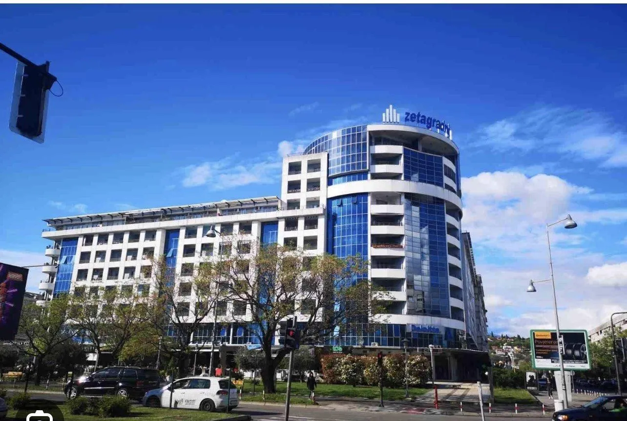 Modern multi-story building with a striking blue glass facade.