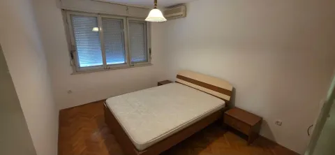 Spavaća soba sa bračnim krevetom, noćnim ormarićima i prozorom sa roletnama. - image 12