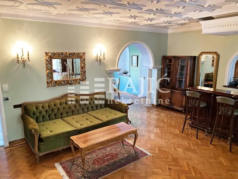 Spacious living room with a sofa set, wooden furniture and a decorative ceiling.