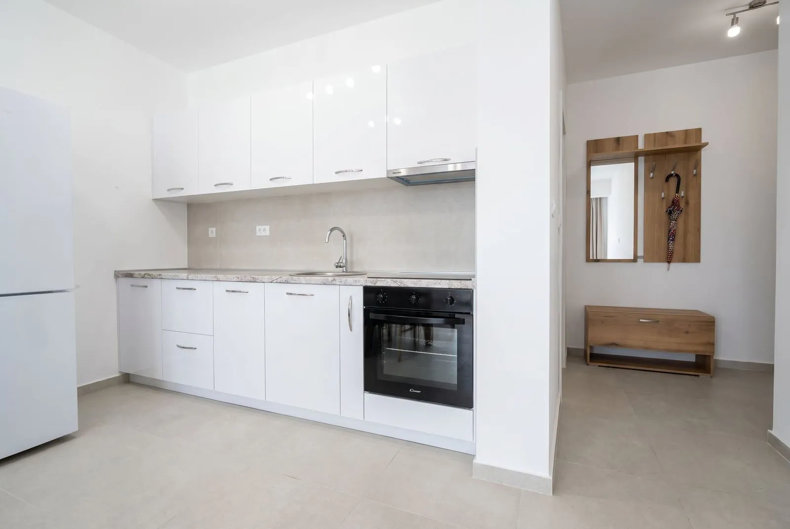 Modern kitchen with white cabinetry and a built-in oven.