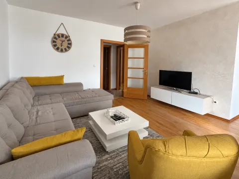 Spacious living room with a sectional sofa, coffee table, and television. - image 3