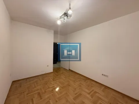 Empty room with hardwood parquet flooring and white walls. - image 5