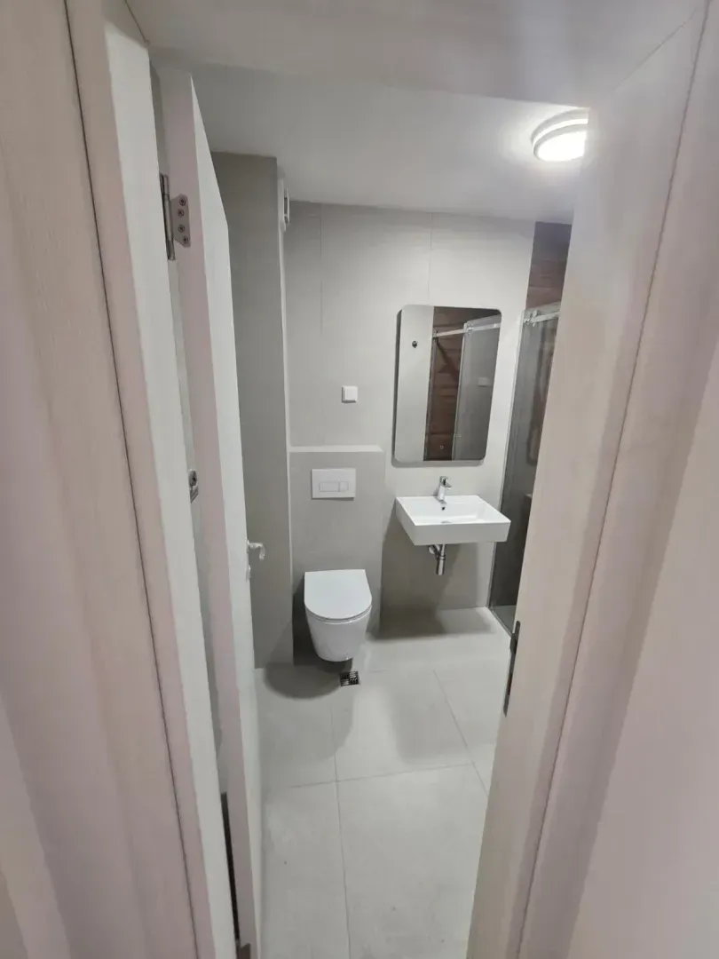 Pogled na moderno uređeno kupatilo sa sanitarijama i tuš kabinom.