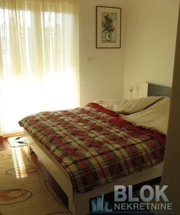 Bedroom with a double bed and a window covered with curtains.