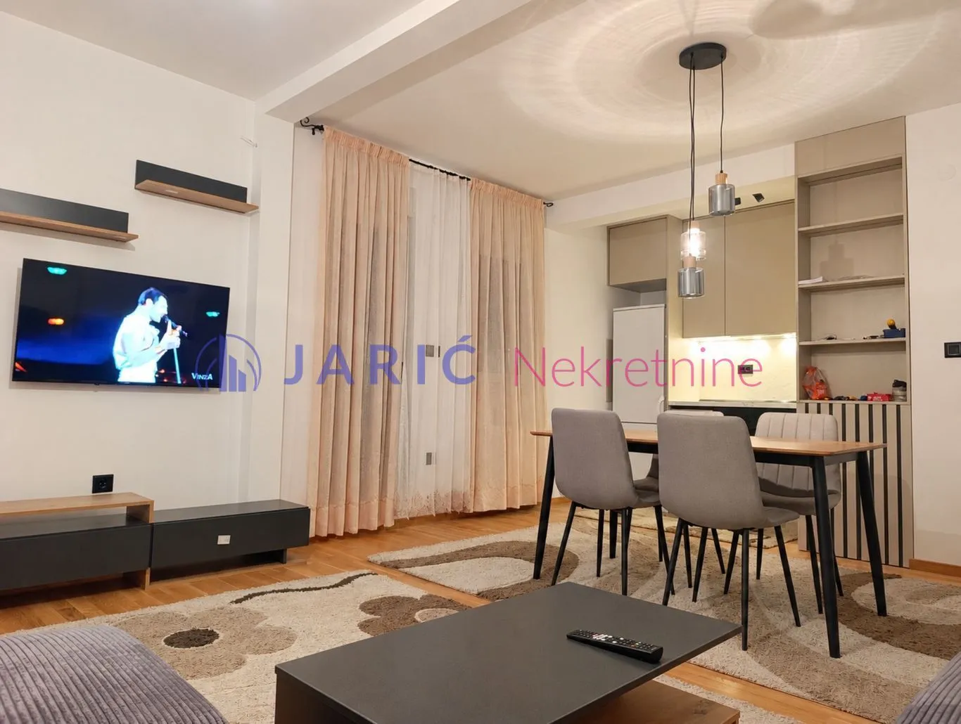 Modern living room with a dining area and kitchen in the background.