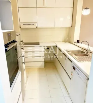Modern white kitchen with built-in appliances and a sink. - image 9