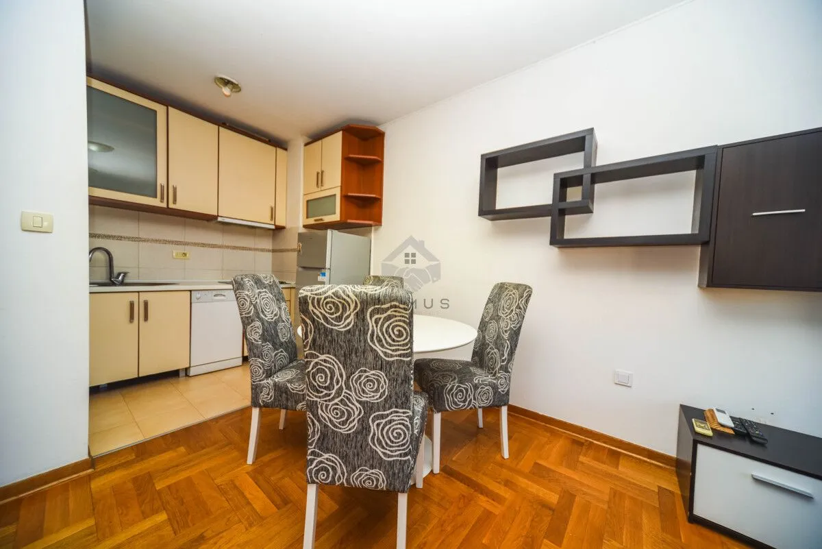 Kitchen with dining area and wooden flooring.