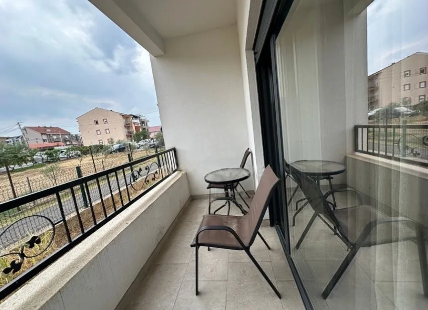 Covered balcony with a table and chairs and a view of the surroundings.