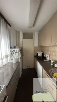 Small narrow kitchen with light-colored cabinets and a refrigerator. - image 4