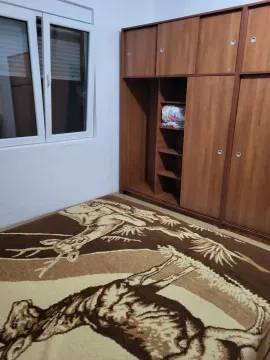 Soba sa velikim drvenim ormarom i dezeniranim tepihom. - image 4