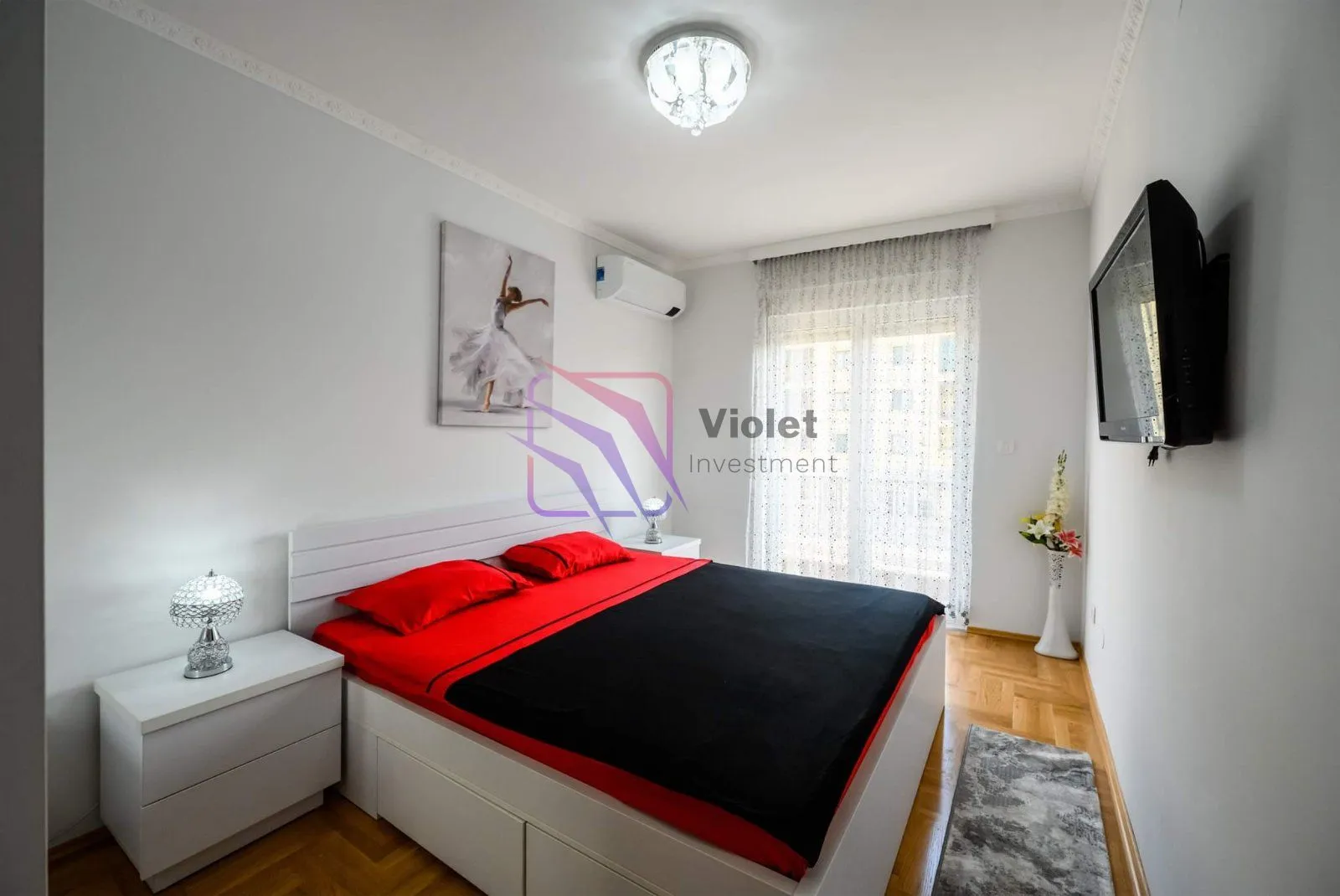 Furnished bedroom with a large double bed and a wall-mounted TV.