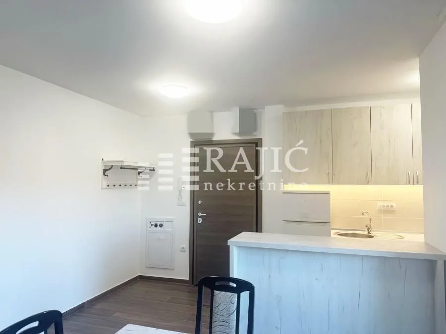 Small kitchen with a breakfast bar connected to the living area.