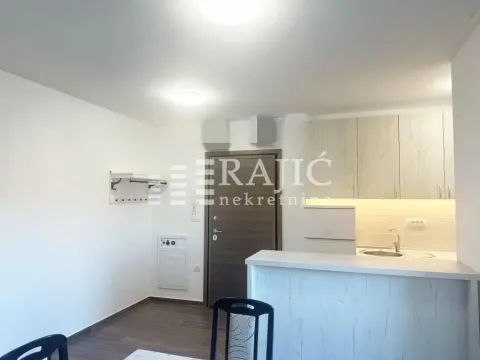 Small kitchen with a breakfast bar connected to the living area. - image 6