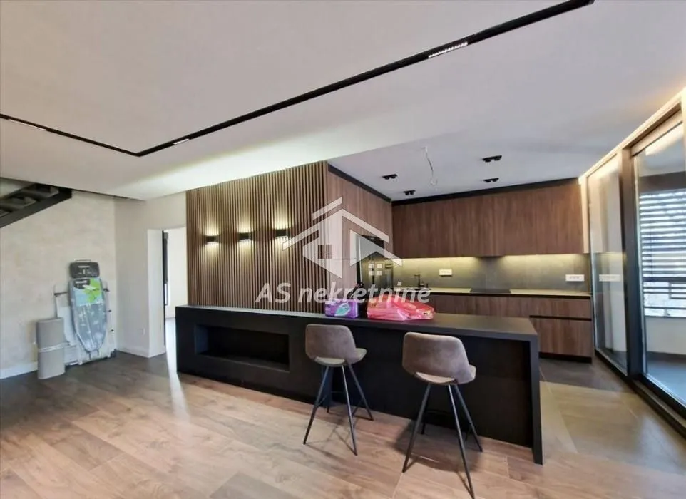 Modern kitchen with a breakfast bar and wooden wall panels.