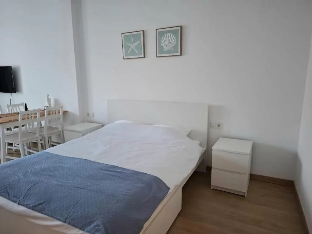 Bright bedroom with a double bed and nightstands.