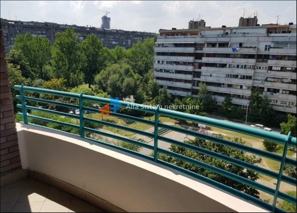 View from the balcony overlooking surrounding buildings and greenery.