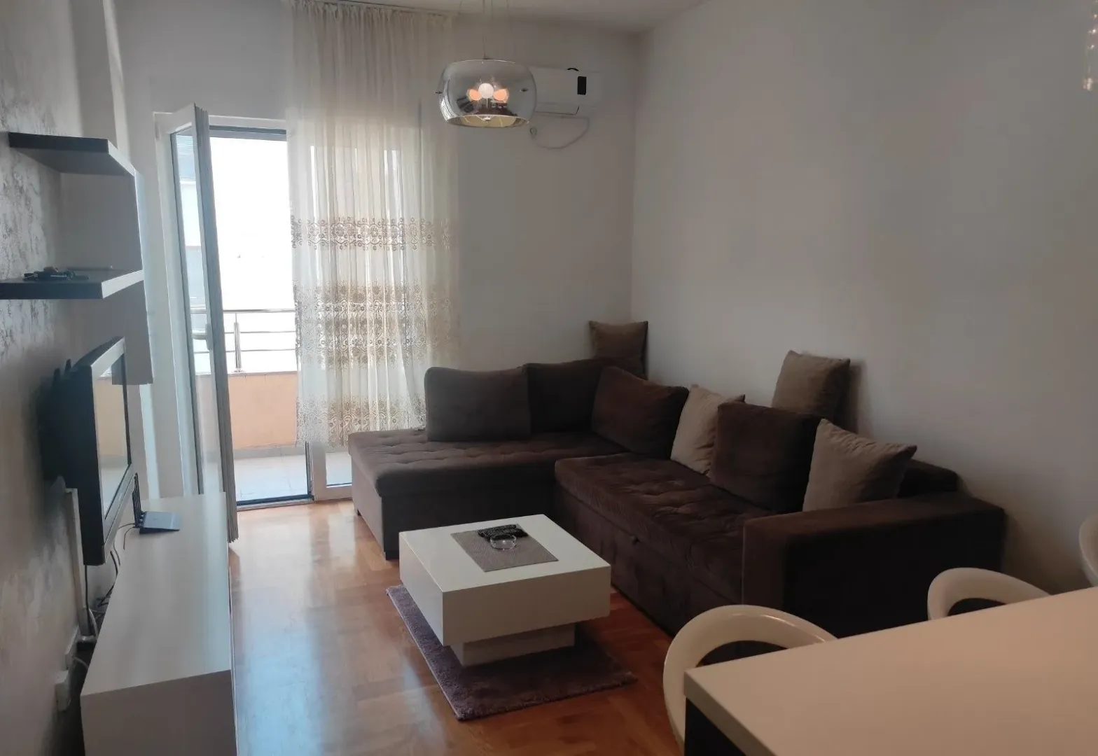 Living room with a sectional sofa, coffee table, and access to the terrace.