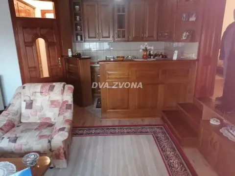 Traditional kitchen with wooden cabinetry and a breakfast bar connected to the living area. - image 22