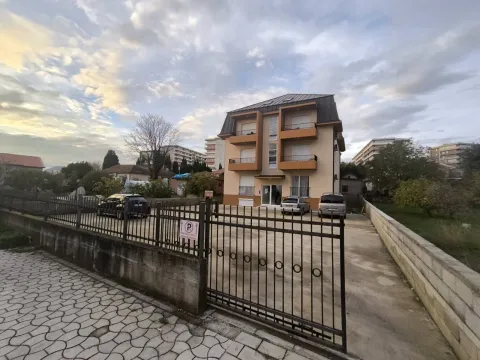 Exterior view of a residential building with a gated parking lot. - image 8