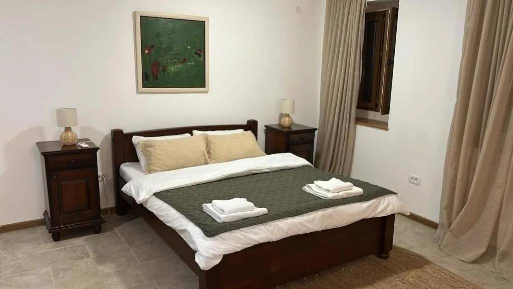Bedroom with a double bed, bedside tables and a painting on the wall.