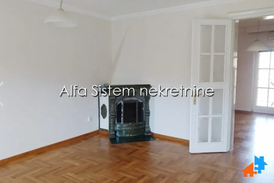 Living room with a fireplace and parquet flooring.
