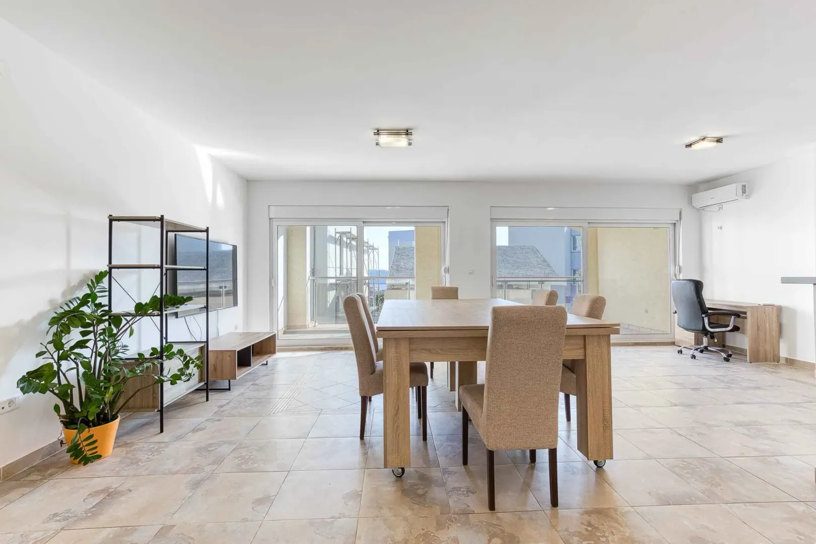 Spacious living room with a dining table and access to the terrace.