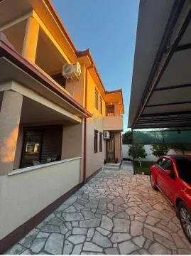Eksterijer kuće sa dvorištem, popločanim prilazom i parkiranim automobilom. - image 16