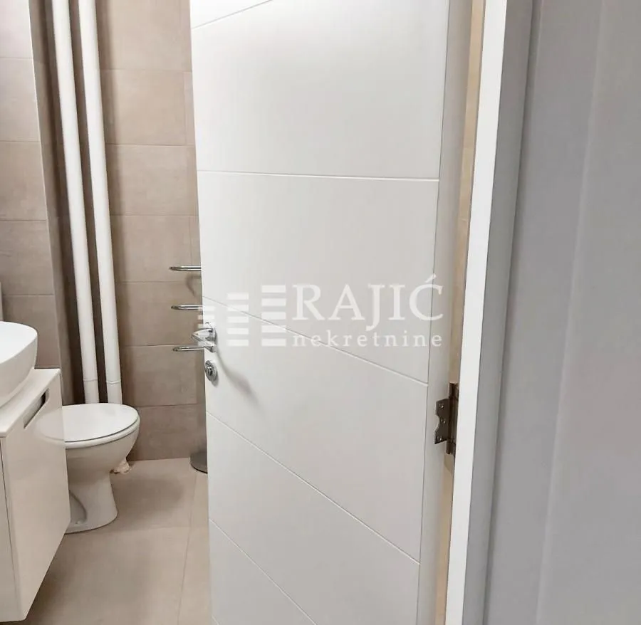 View of the bathroom through an open white door.