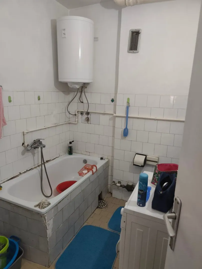 Manje opremljeno kupatilo sa kadom i bojlerom.
