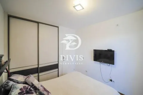 Nameštena spavaća soba sa bračnim krevetom, velikim plakarom i televizorom na zidu. - image 11
