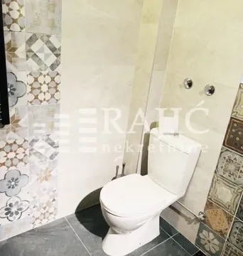 Manje kupatilo sa WC šoljom i dekorativnim pločicama. - image 14
