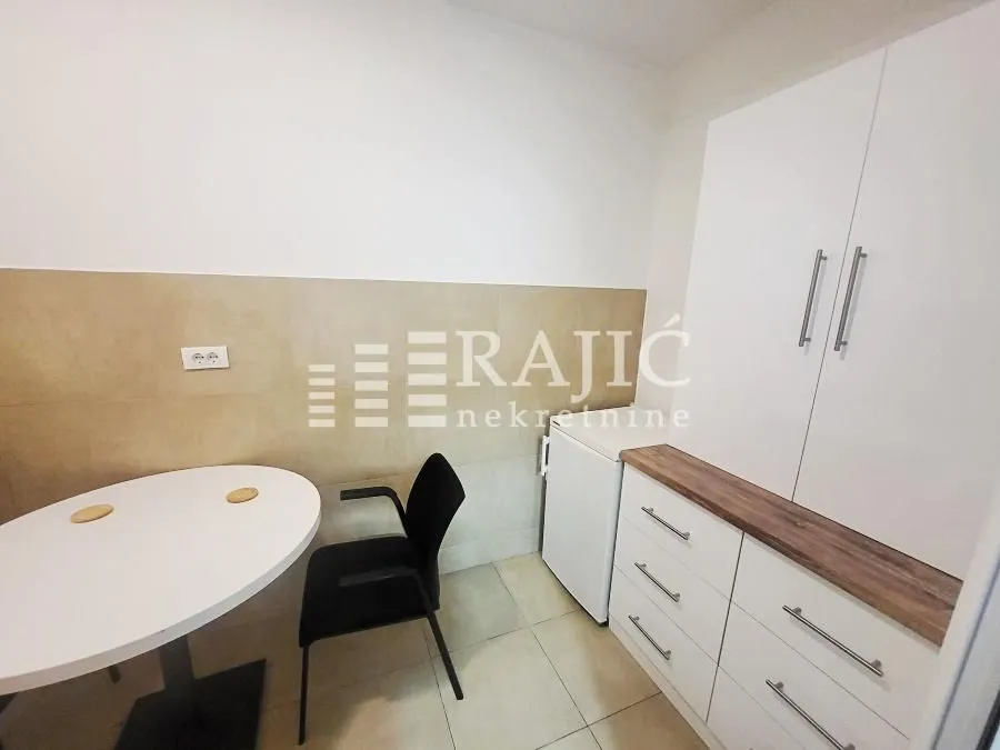 Smaller kitchen with a dining table and white cabinets.