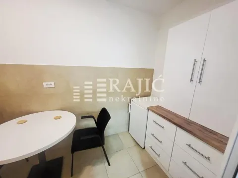 Smaller kitchen with a dining table and white cabinets. - image 8