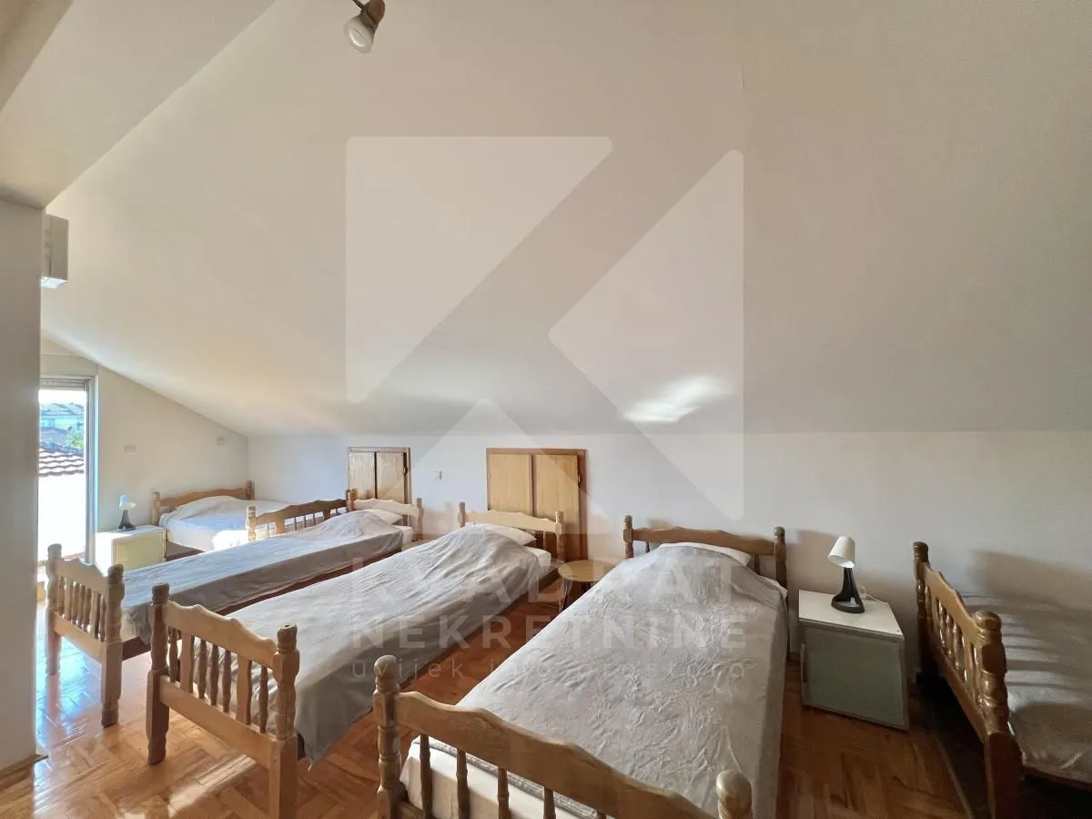 Attic furnished with multiple wooden beds.