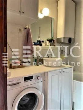 Smaller bathroom with a washbasin, washing machine, and water heater. - image 7
