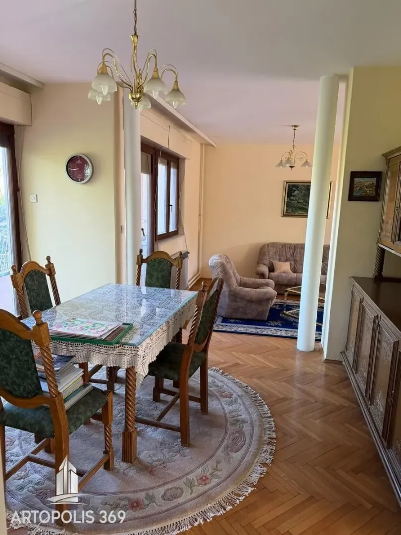 Prostrana dnevna soba sa trpezarijskim delom i garniturom za sedenje.