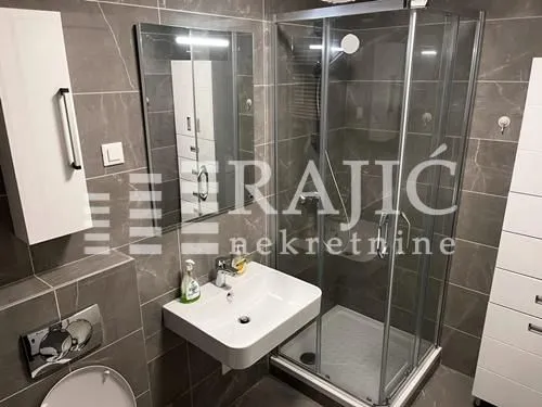 Modern bathroom equipped with a shower cabin and washbasin.