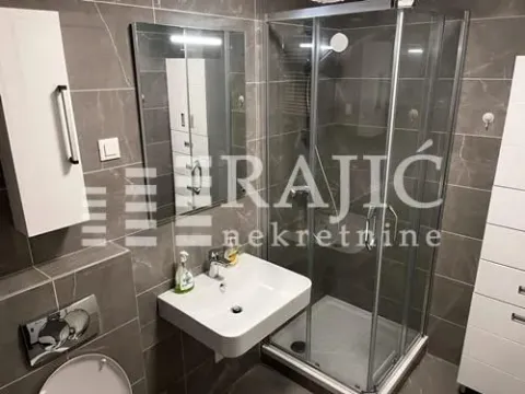 Modern bathroom equipped with a shower cabin and washbasin. - image 7