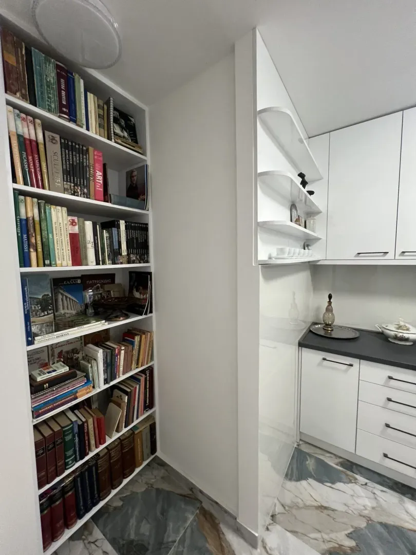 Bright kitchen featuring a built-in bookshelf and marble flooring.