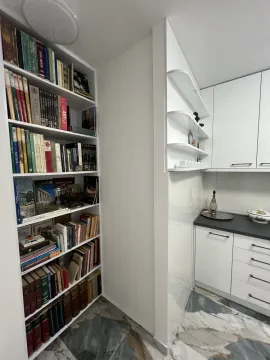 Bright kitchen featuring a built-in bookshelf and marble flooring. - image 5