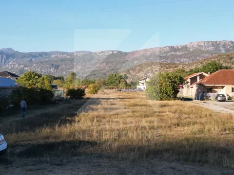 Pogled na prostrano zemljište sa okolnim kućama i planinama u pozadini. - image 7