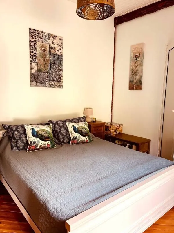 Furnished bedroom with a double bed, decorative pillows, and wall art.
