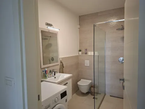 Moderno opremljeno kupatilo sa tuš kabinom i veš mašinom. - image 7