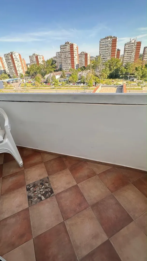Small tiled balcony with a city view.