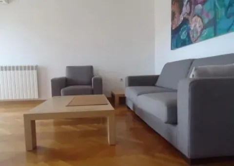 Bright living room with a grey sofa set and a wooden coffee table. - image 2