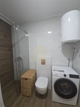 Savremeno opremljeno kupatilo sa tuš kabinom i veš mašinom. - image 15